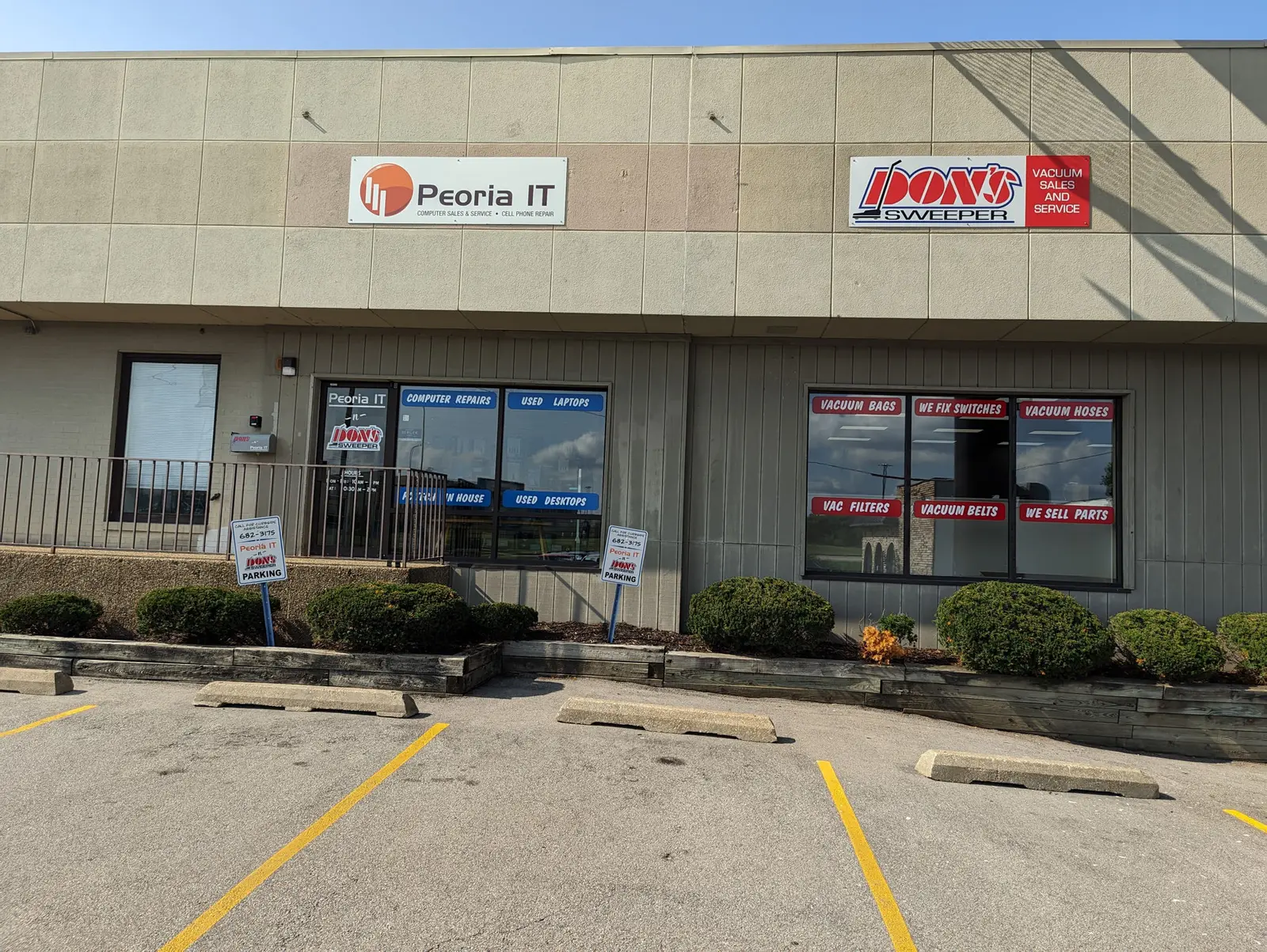 The Don's Sweeper shopfront on North Brandywine Drive, its sign reading Vacuum Sales and Service, sharing the unit with Peoria IT. Window decals list vacuum bags, belts, filters, hoses, switch repair and parts.